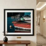 Framed photograph of colorful boats reflected in calm water
