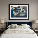 Framed boat artwork above a navy upholstered bed