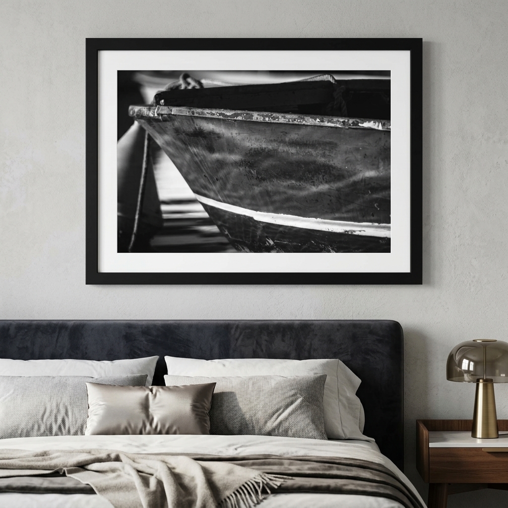 Black-and-white boat photograph above modern upholstered bed