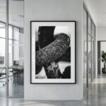 Framed black-and-white abstract photograph in modern office hallway