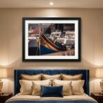Framed colorful boat photograph above elegant blue upholstered bed