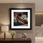 Framed colorful boat photograph above a console table