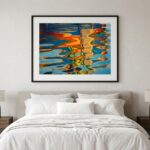 Colorful abstract water reflection artwork above white bed