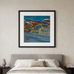 Framed abstract water reflection artwork above neutral bed