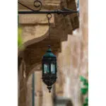 Ornate metal lantern hanging beneath a stone archway