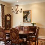Traditional dining room with chandelier, grandfather clock, and floral chairs