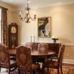 Traditional dining room with chandelier, grandfather clock, and floral chairs