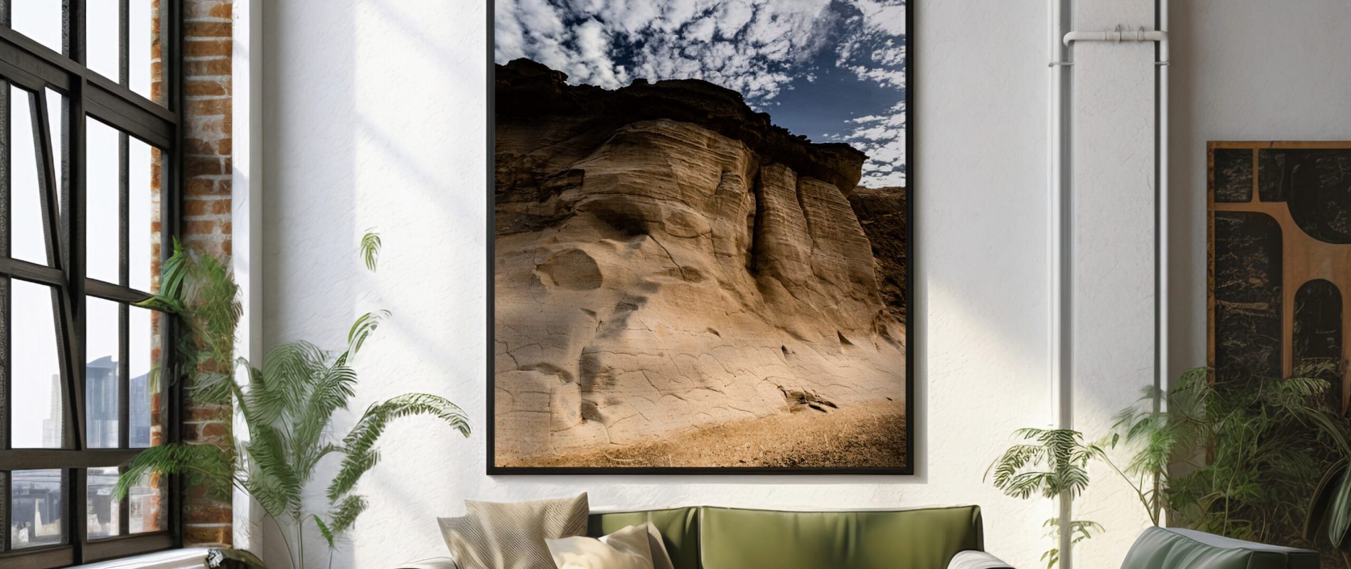 A large framed photo of a desert landscape at Gozo Qbajjar, displayed prominently in a stylish living room setting