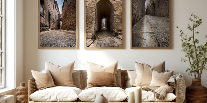 A cozy living room featuring a couch, coffee table, and two framed pictures of Mdina's timeless streets.